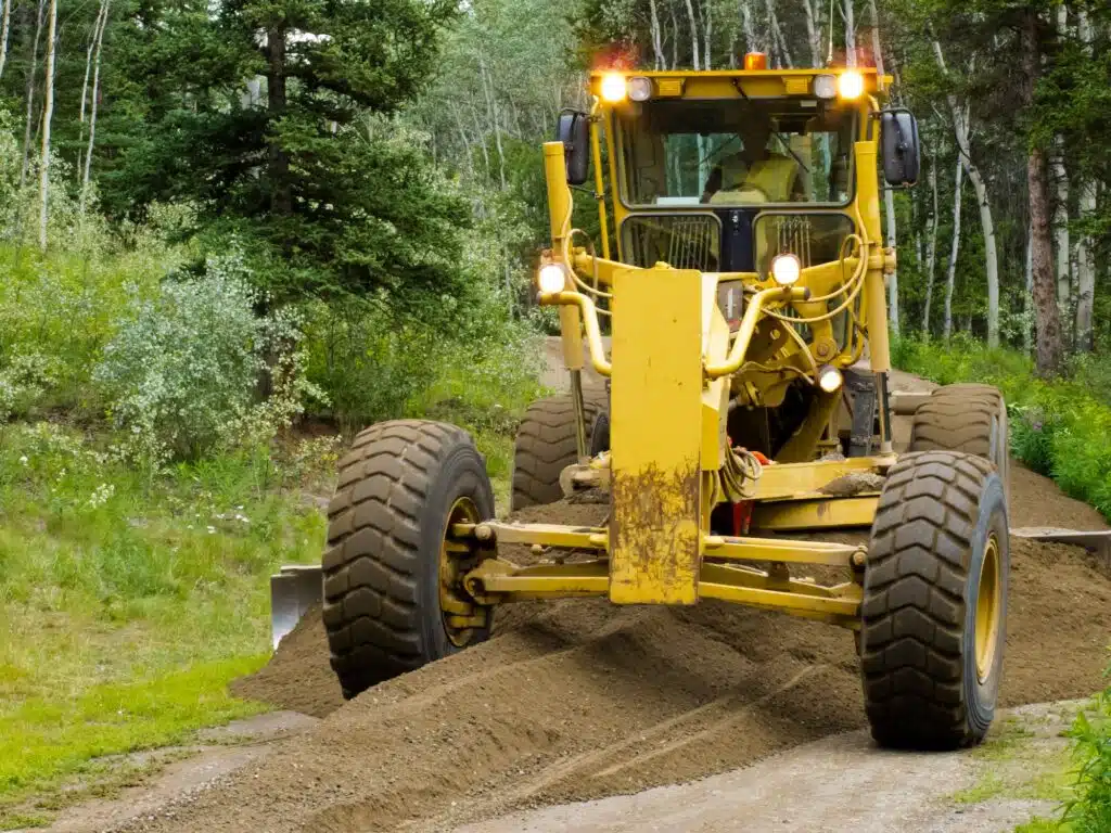 Grader resurfacing narrow rural road